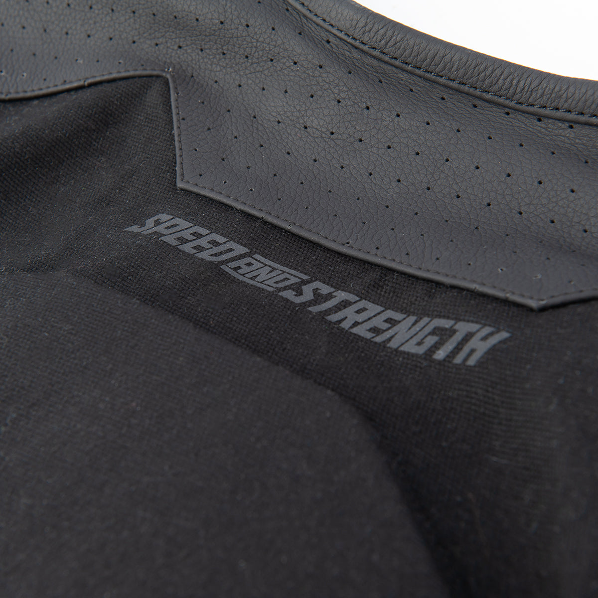 Black perforated leather accent with 'Speed and Strength' branding on canvas on a white background