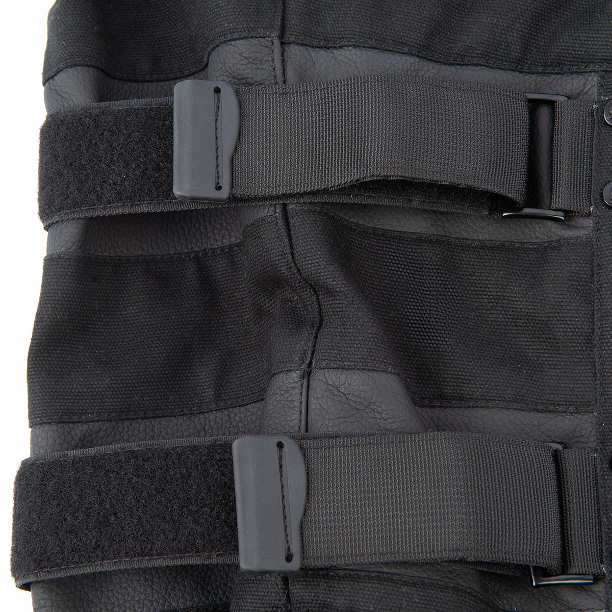 Black tactical vest with multiple straps on a white background